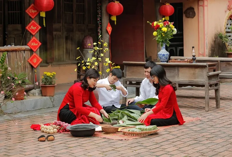 Chụp ảnh áo dài Tết ngồi gói bánh chưng đón Tết Nguyên Đán