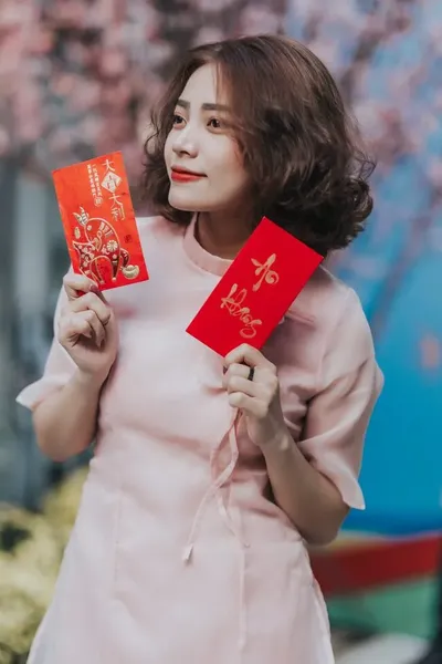Tạo dáng chụp ảnh áo dài với bao lì xì