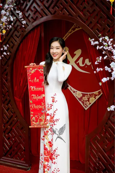 Tạo dáng chụp ảnh áo dài bên câu đối