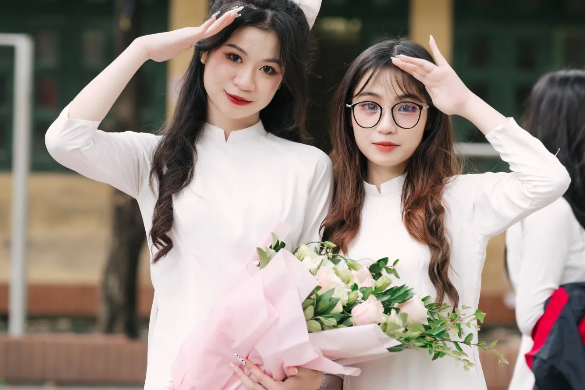 Tạo dáng chụp kỷ yếu trong bộ áo dài trắng kết hợp cùng hoa là một trong những cách chụp đẹp và tinh tế, đặc biệt dành cho các bạn nữ