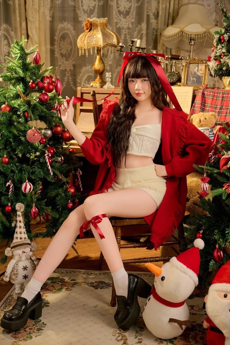 Tạo dáng với cây thông noel đặt ghế ngồi cạnh