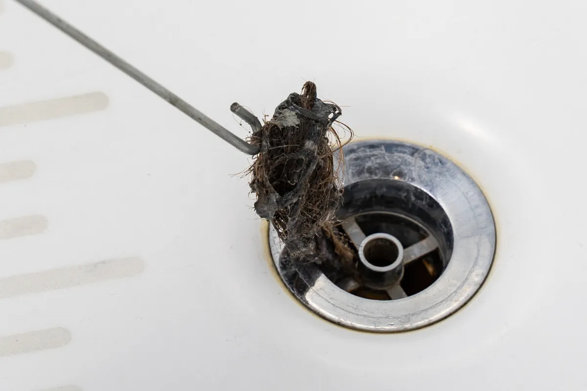 Loại bỏ tóc trong lavabo bằng móc phơi quần áo