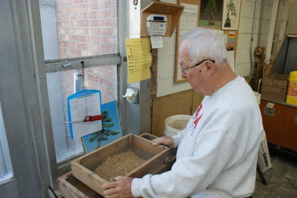 Tình nguyện viên Dick Anderson sàng đất trước khi trồng cây