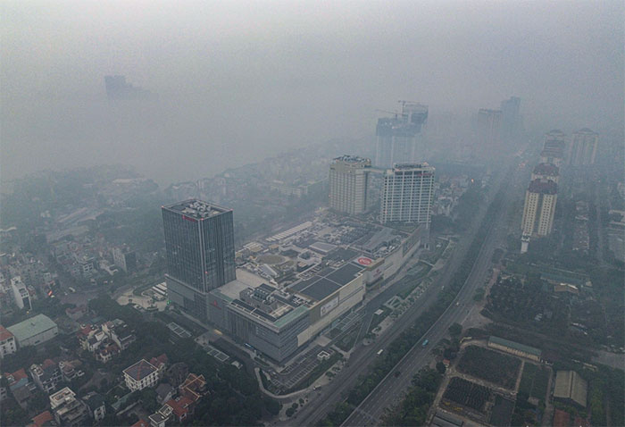 Nhà cao tầng ở Hà Nội biến mất trong làn sương mù cùng bụi mịn