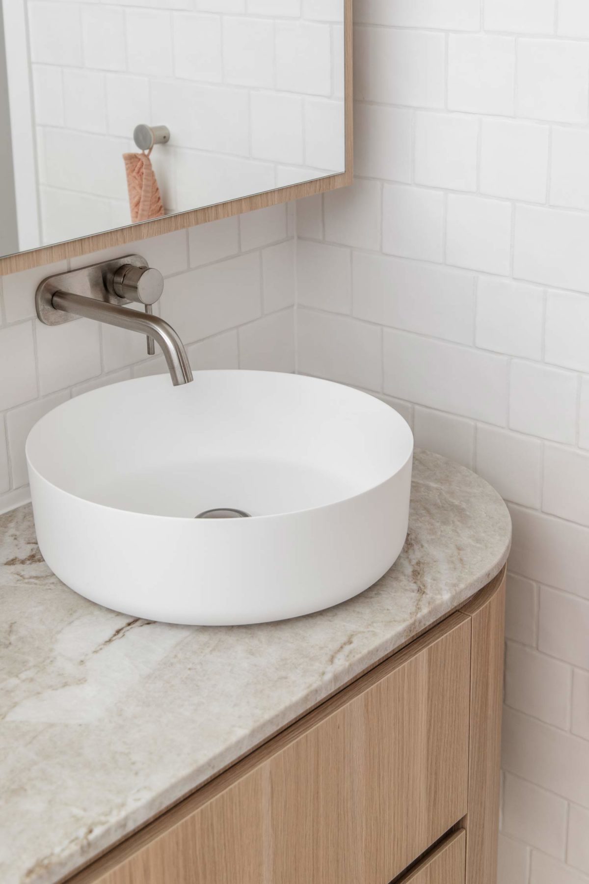Quy luật thống nhất thông qua các lớp hoàn thiện thiết kế vòi nước giống nhau trong nhà bếp và phòng tắm.