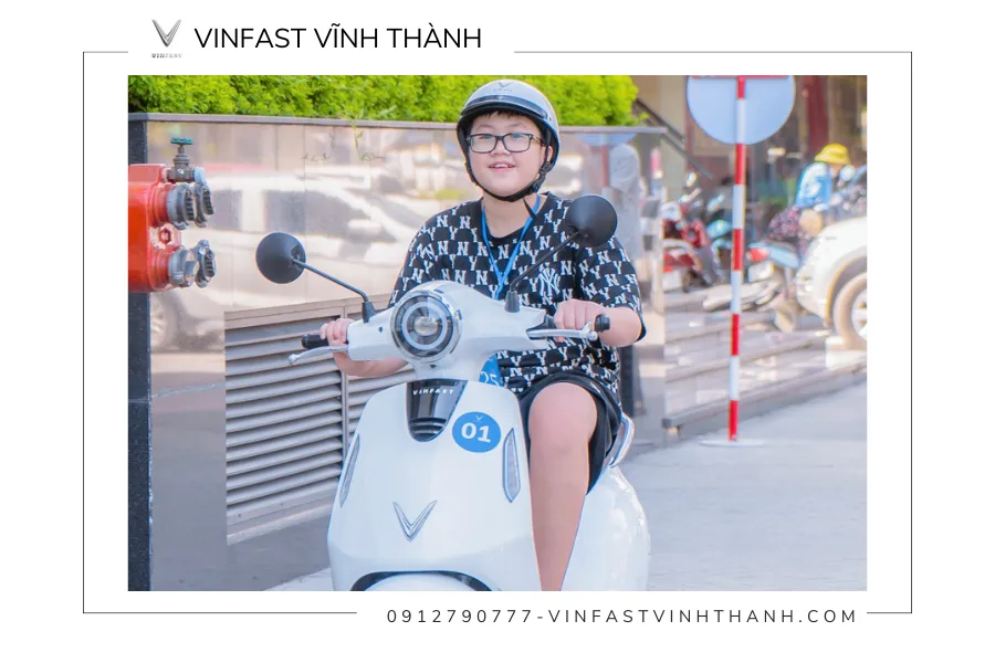 cậu bé đang ngồi trên xe máy điện vinfast